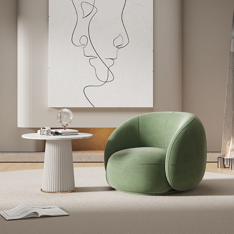 Modern living room: green circular armchair beside a white pedestal table with books, abstract line-art on the wall.